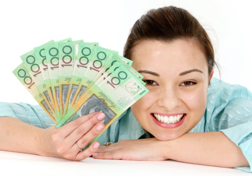 Young woman holding a bundle of $100 bills